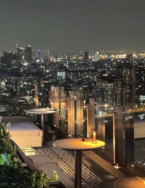 Rooftop lounge at night above the Bangkok city lights