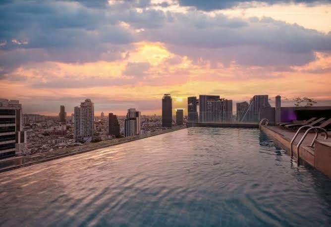 Rooftop infinity pool over the Bangkok skyline at sunset